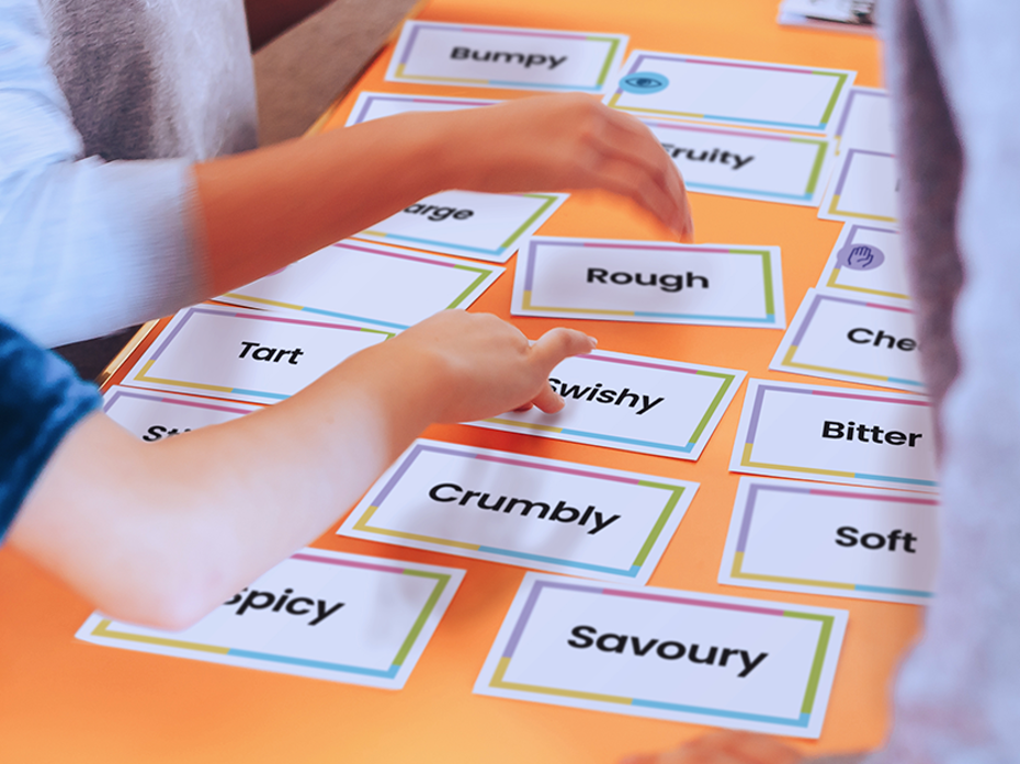 Adjective food cards laid out on a table