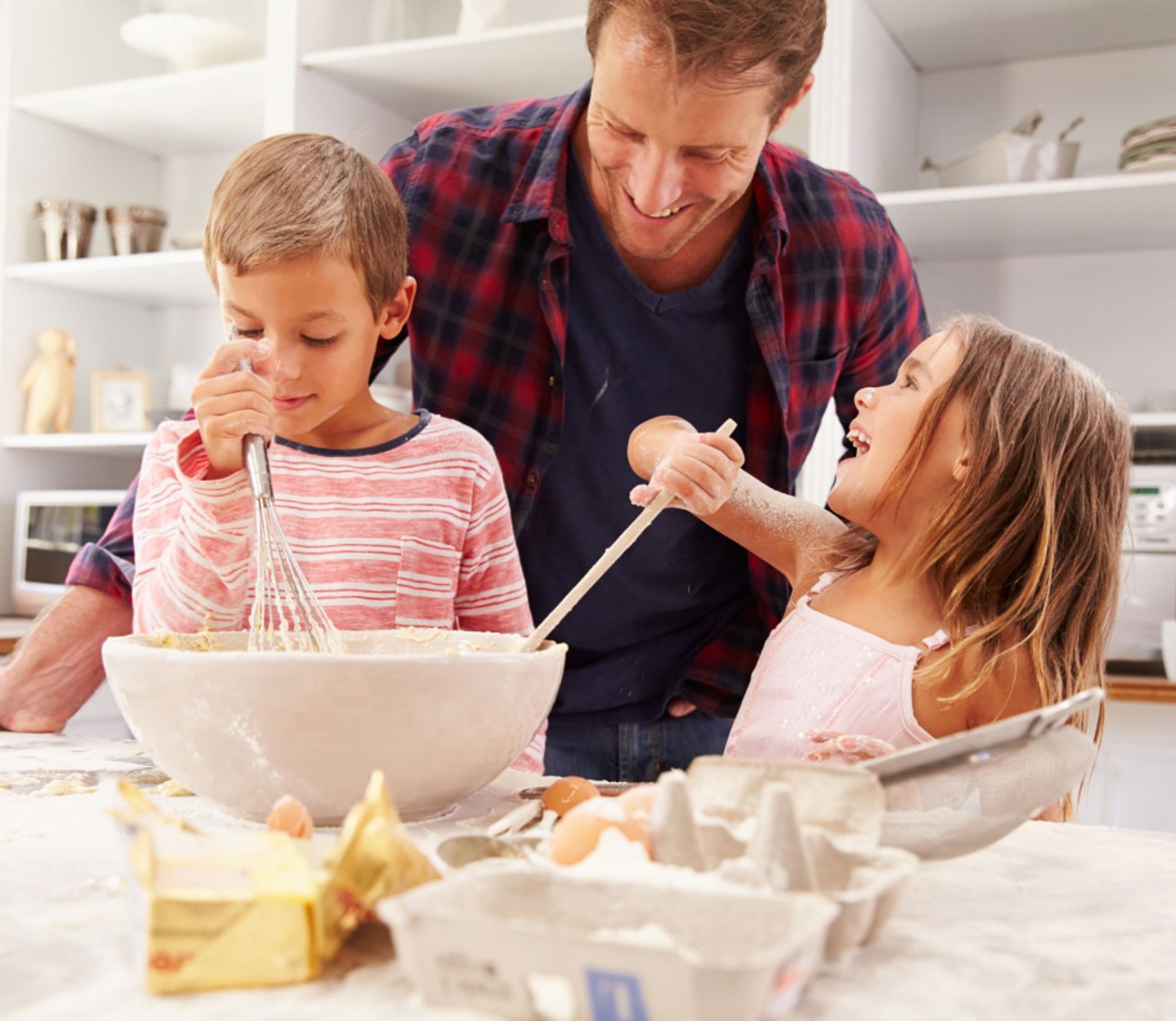Father and two children cooking in kitchen