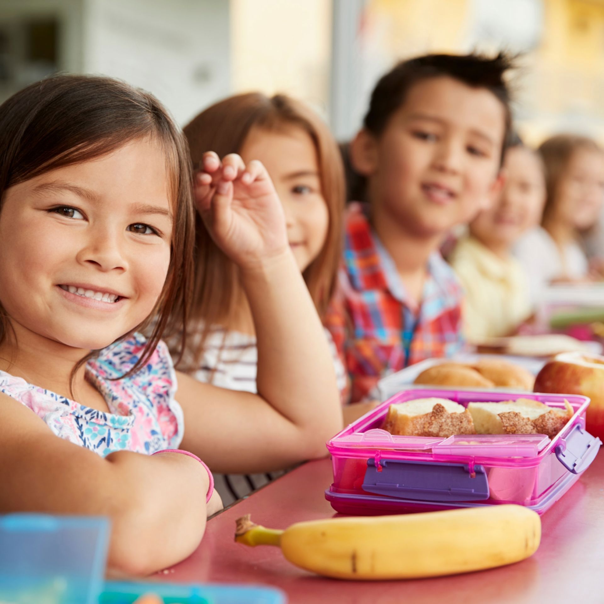 Young girl smiling while eating her lunch outside