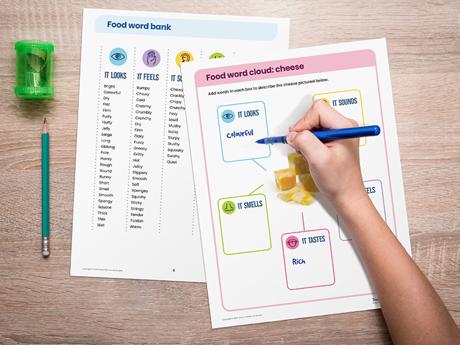 Food word games activity sheets on a table with a child writing on them